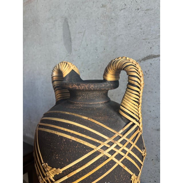 A striking large-scale stoneware vessel combining earthy ceramic form with hand-applied cane detailing. Crafted in the...