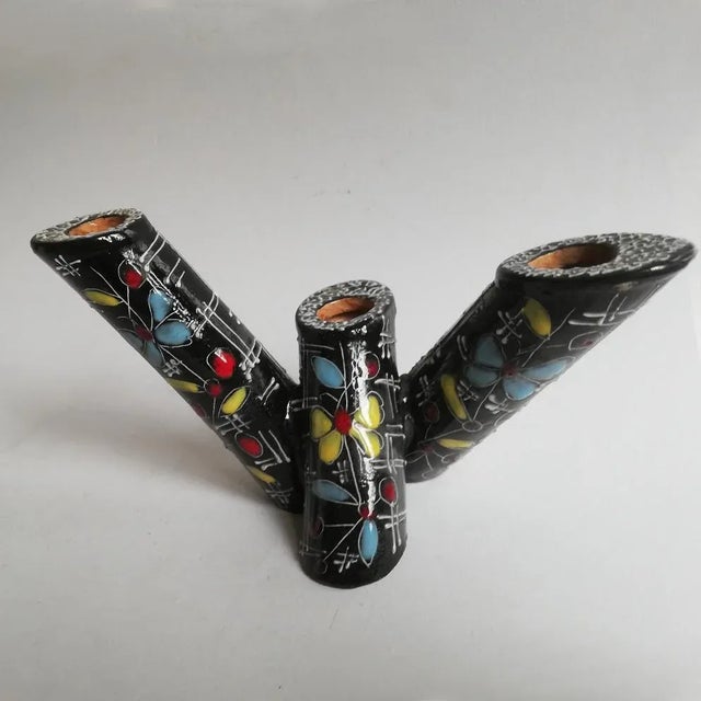 This is a 3 light candleholder in terracotta, embellished with polychrome enamels, signed R. Rolli Derut.