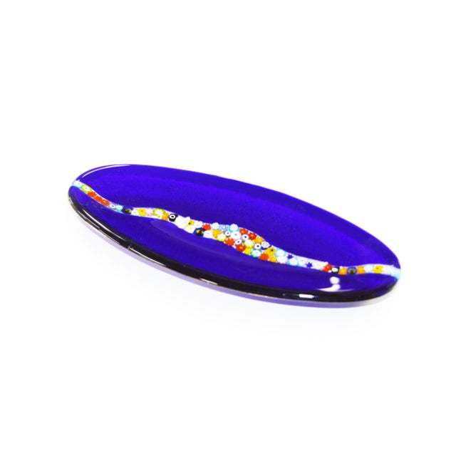 Oval decorative plate in transparent cobalt blue Murano glass, with central decoration of Venetian millefiori murrine.
