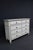 A substantial eight-drawer dresser by Millennium by Ashley, finished in a soft antiqued white with subtle distressing that...