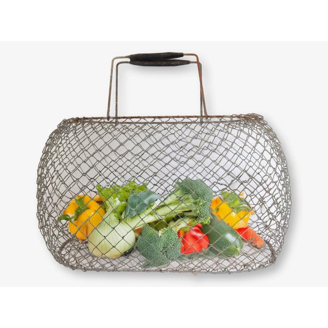 Collapsible wire market basket, France, early 20th century. Handwoven steel mesh with a patinated iron frame and double...