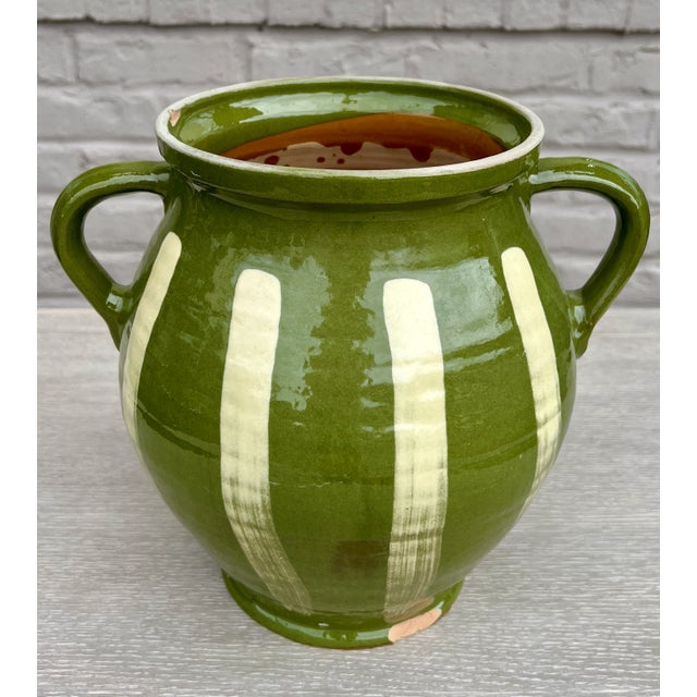 Beautiful in both its shape and decoration, this vintage glazed earthenware vessel is distinguished by its two handled...