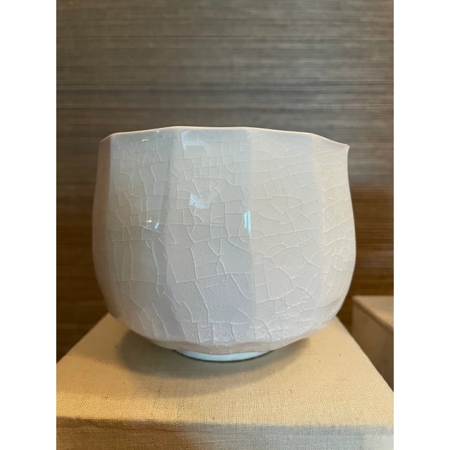 A set of five Japanese chawan tea bowls and carved ceramic tea box. Each with a fine crackle glaze, lotus shape and...