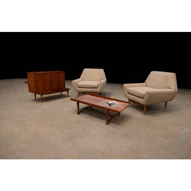 A refined pair of Brazilian Modern lounge chairs crafted in solid caviúna wood, Brazil, 1950s. While the designer remains...