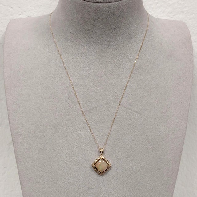 A refined 18ct yellow gold pendant showcasing a 1.97ct opal with shimmering flashes of green and ember. Its cushion‑shaped...