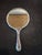 This vintage hand mirror appears to be an Art Nouveau style silver-plated piece dating from roughly 1900 to 1920. Design...