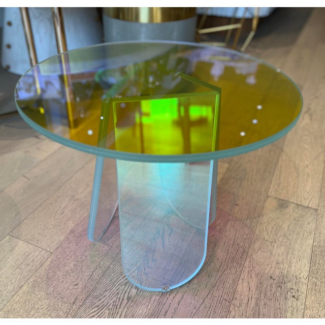 A group of low laminated and glued glass tables, characterized by a special iridescent multicolored finish; the nuance...