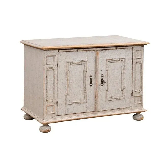 A Swedish Baroque painted wood buffet from the Mid-18th Century, with two doors, geometric carved panels, pull out, bun...