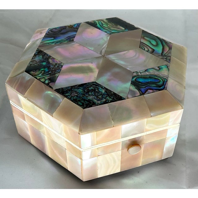 Incredibly iridescent mother of pearl veneered hexagonal box with star design on top. Push bottom locking mechanism, four...