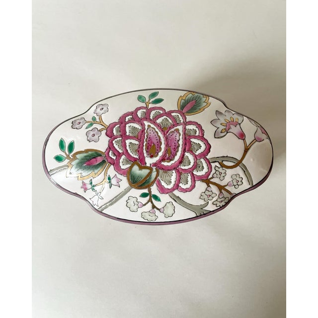 A wonderful shaped mid-century floral box with a background of pale, pink and pink and green flowers.