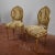 Pair of Napoleon III style gilded chairs with leaf carvings, turned and fluted feet, oval backrest enriched with a small...