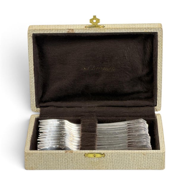 A set of twelve silver-plated cake forks by Christofle, presented in their original fitted Christofle case. The forks...