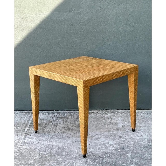 This game table pairs a clean, tapered silhouette with the natural texture of tightly woven rattan, its square tabletop...