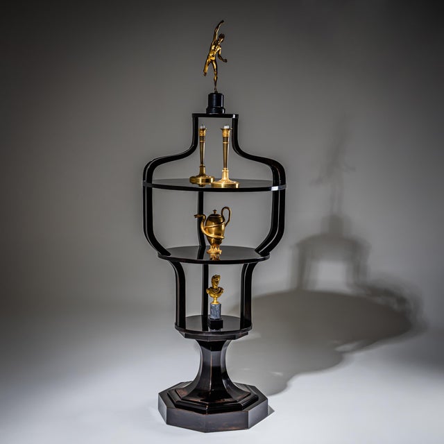 Elegant ebonized étagère raised on an octagonal base with a tapered central column. Above rises a four-tiered structure...