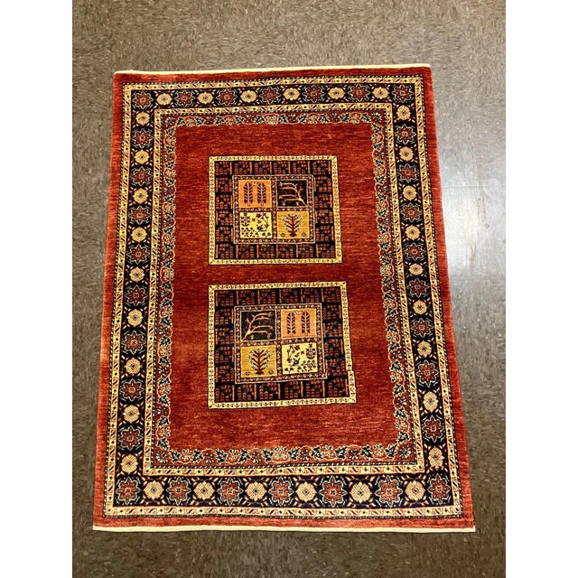 Vintage Hand-knotted Persian Kashkoli wool rug featuring a rich red field with two central square medallions, each divided...