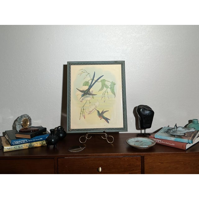A beautifully composed mid-century hummingbird lithograph published by IBF Co., presented in its original carved wood...