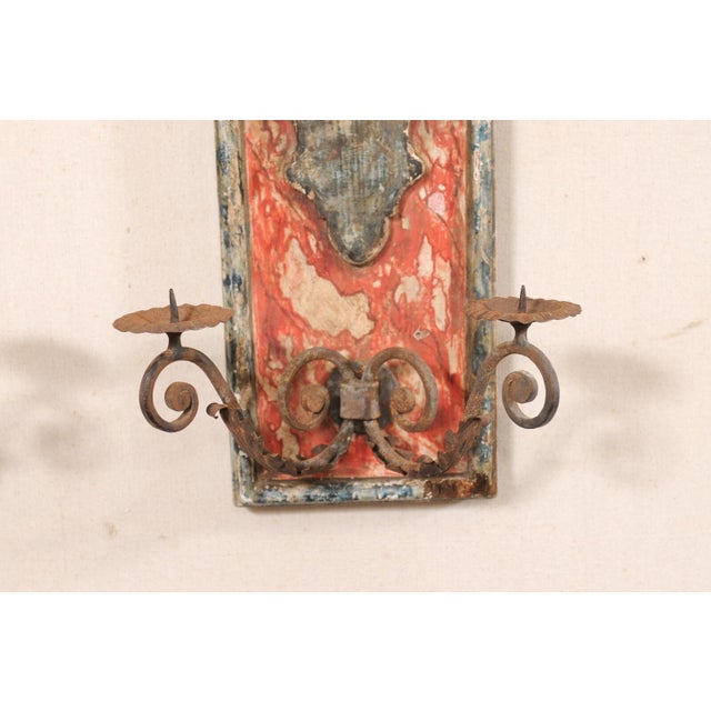 A pair of Italian painted wood wall plaques with iron candle arms from the 19th century. This antique pair of wall...