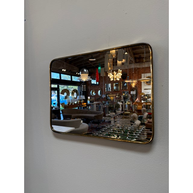Refined and understated, this mid-century Italian mirror features a softly rounded rectangular form framed in a slender...