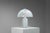 A strikingly large table lamp by Doria Leuchten, sculpted entirely from luminous bubble glass. The substantial glass base...