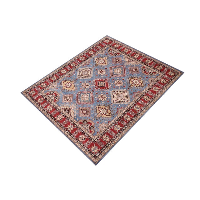 Enhance your home with this exquisite hand-knotted Kazak rug, crafted from fine hand-spun wool and dyed with all-natural...
