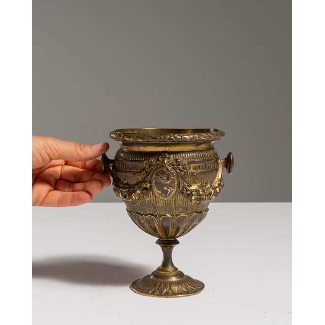 This 19th century Victorian brass chalice from France is cast in brass as a footed chalice with two handles and relief...