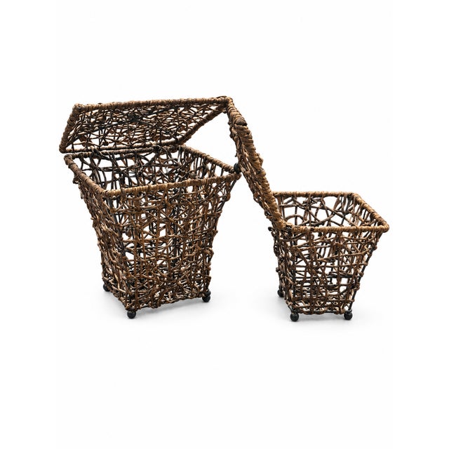 A charming pair of woven metal footed baskets, each with a hinged lid. The smaller basket fits inside the larger for easy...