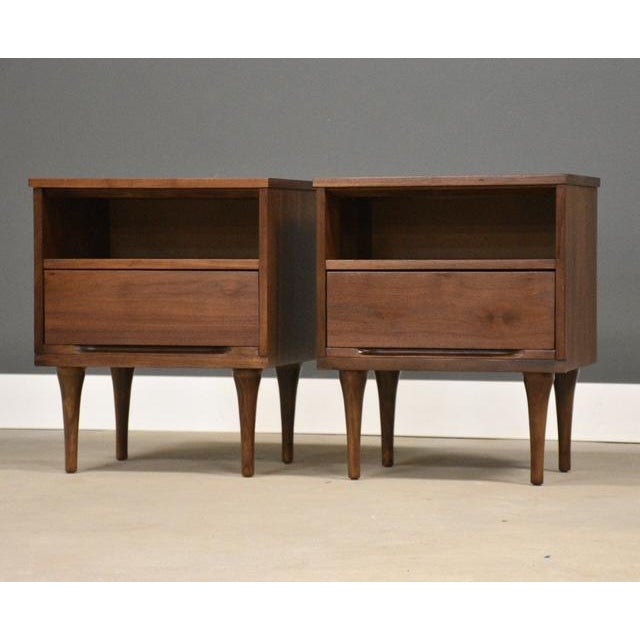 A pair of mid century modern walnut nightstands with a single drawer made by Stanley Furniture. Professionally refinished....