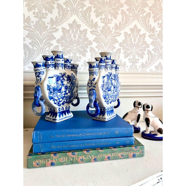 A striking pair of blue and white porcelain five-spout vases, hand-painted with dynamic dragons chasing the flaming...