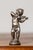 This charming early 20th-century French miniature statuette captures the playful elegance of a cherubic figure joyfully...