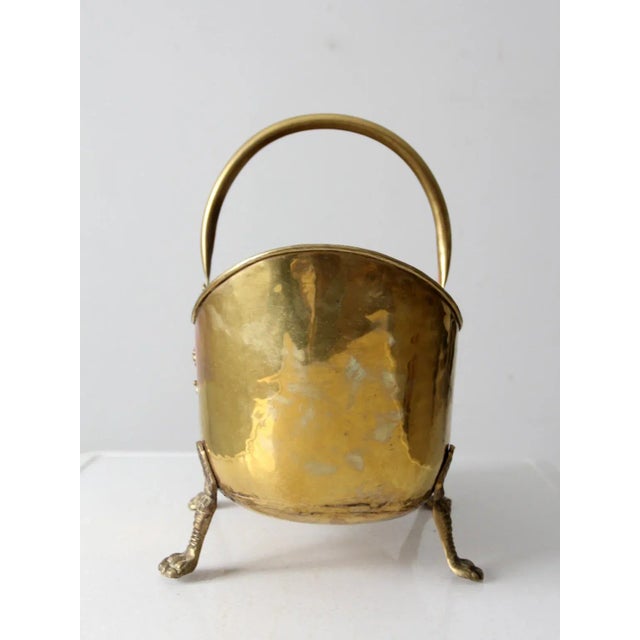 This is a distinguished antique brass log bin. The impressive craftsmanship of the brass firewood/kindling holder features...