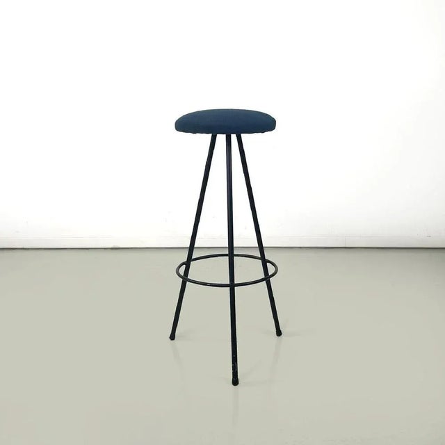 Italian mid-century modern three legs black metal and blue fabric stool, 1950s High bar stool with round base. The seat is...