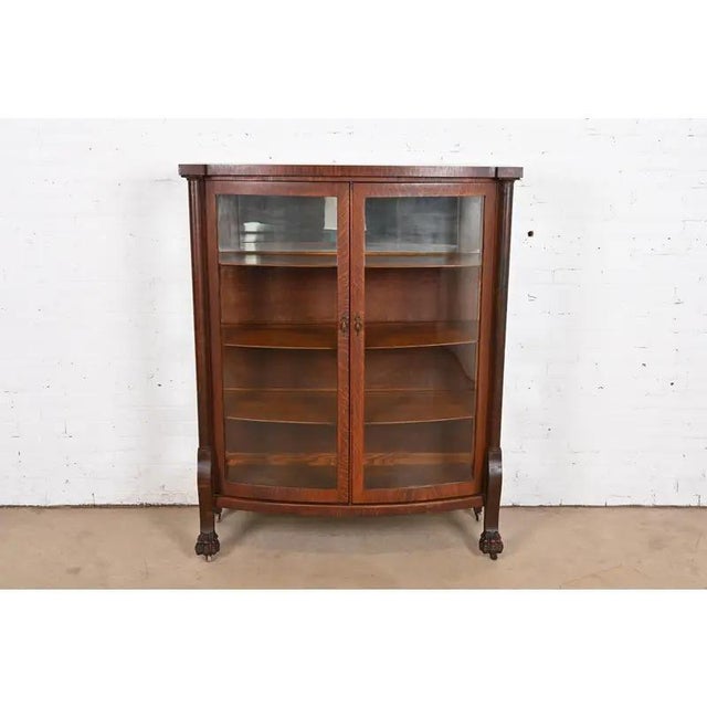 A beautiful antique American Empire or Victorian bow front bookcase or display cabinet In the manner of R. J. Horner & Co....