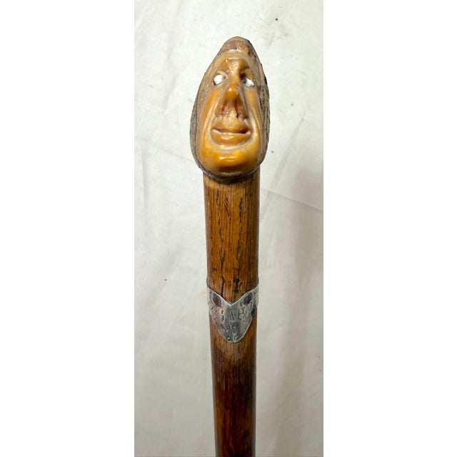 This Antique 19th century hand carved nut, wood, and sterling silver figural walking stick cane is a unique and historical...