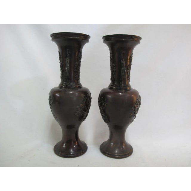 Pair of bronze Japanese vases or urns. Heron and lotus flower design with stylized bamboo handles. Each measures 15" tall...
