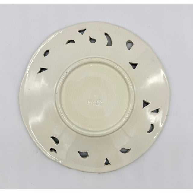 This beautiful 8" reticulated plate is one of five in our collection, each with a unique floral majolica painting with...