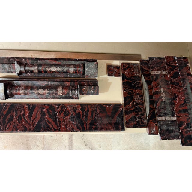 An exceptional early 19th-century marble fireplace surround, dated 1818, executed in richly veined red and black marble...