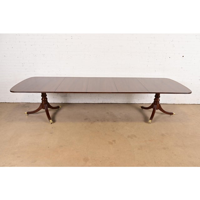 An exceptional Georgian or Regency style double pedestal extension dining table By Henredon USA, Late 20th Century...