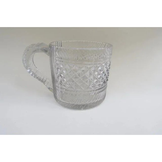 Nice cut glass half pint tankard with applied handle. Measures 3 1/2" tall by 3 1/2" diameter. Very good condition.