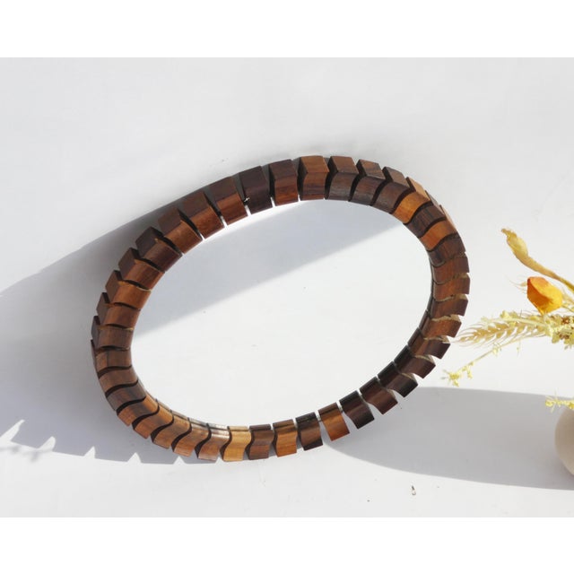 A mid century Scandinavian round wooden mirror made out of teak and rosewood with a geometrically shaped frame. The mirror...