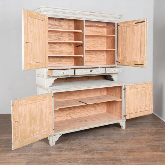 19th century large Swedish Gustavian cabinet, crafted in pine. The upper and lower cabinet doors are detailed with...
