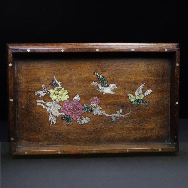 This is a beautifully crafted wooden tray featuring intricate mother-of-pearl (nacre) inlay work. Made from a richly...