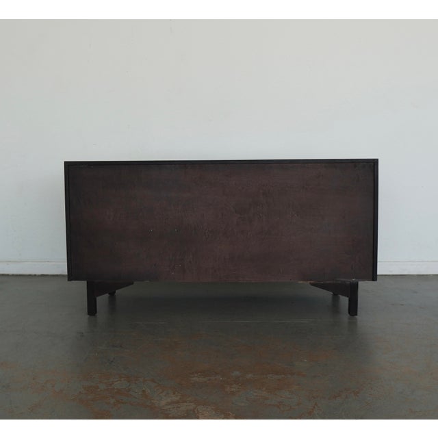 A bold Chinoiserie-inspired dresser in a rich ebonized finish with eye-catching brass hardware. The front features a...