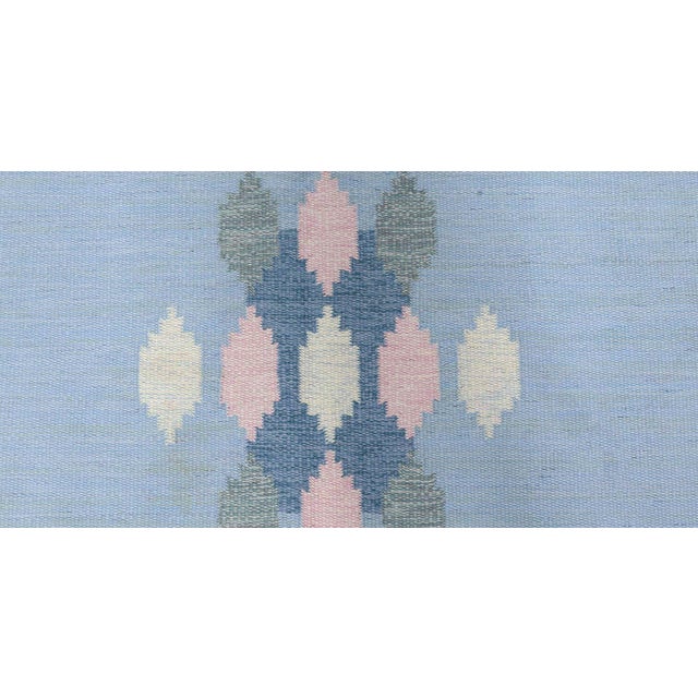 Vintage Swedish rug by Ingegerd Silow. Size: 6'4" × 10'0" (193 × 304 cm). Color: beige, blue, grey, pink. Designed by the...