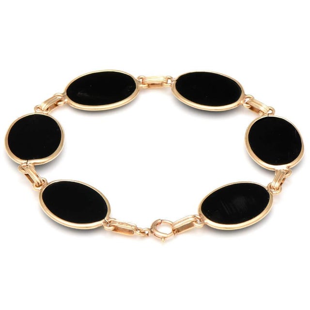 Plunge into outer space with this alluring bracelet that features astonishing black stones and soft yellow gold that...