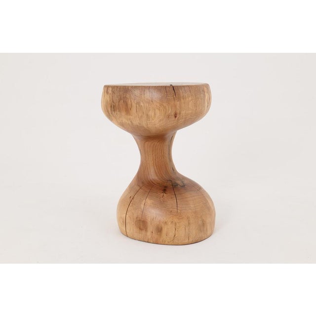 This sculptural side table is a one-of-a-kind work of functional art, carved entirely by hand from a single hardwood log....