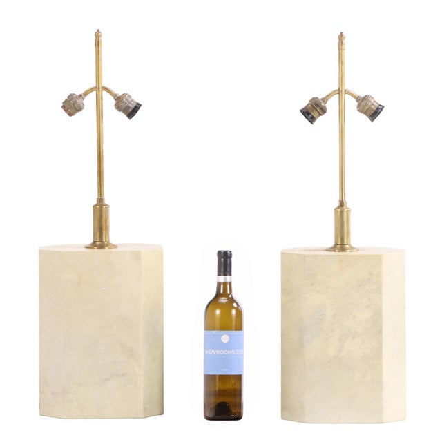 A sophisticated pair of six-sided table lamps dating to circa 1960, crafted in brass and parchment and executed in the...