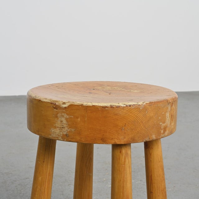 Four-legged stool made of solid pine, France, 1970s. Its thick, circular seat rests on four slightly flared, cylindrical...