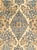 An antique Persian Lavar rug featuring an elegant floral medallion design on an beige field, framed by a deep navy floral...