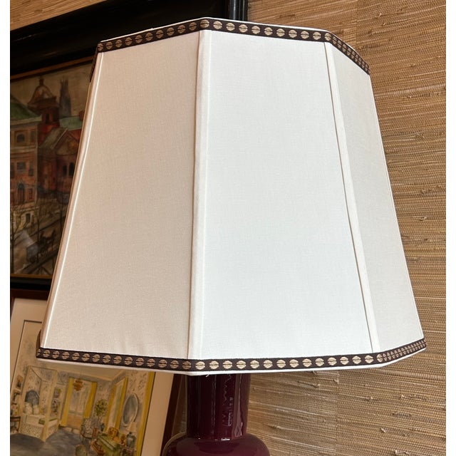Octagonal lampshade out of an ivory pongee silk with a dark brown patterned trim on the top and bottom, with a drop in...