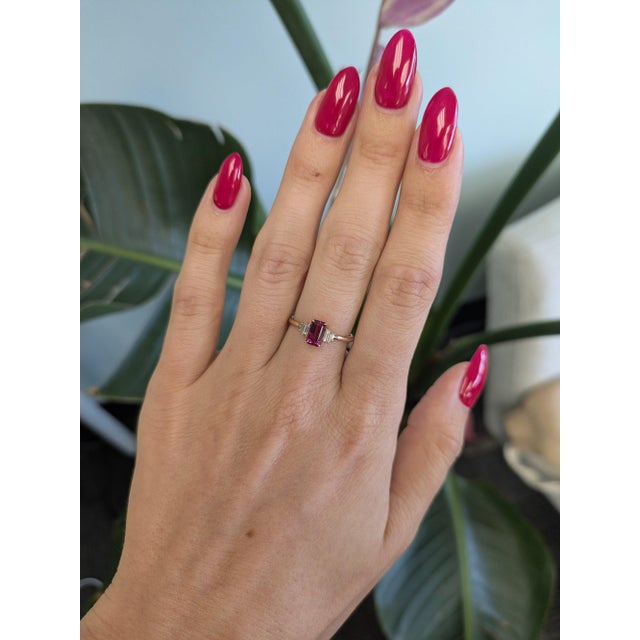 A natural pink tourmaline glows in a soft, rosy pink at the centre of this solid 14K yellow gold ring, accented by four...